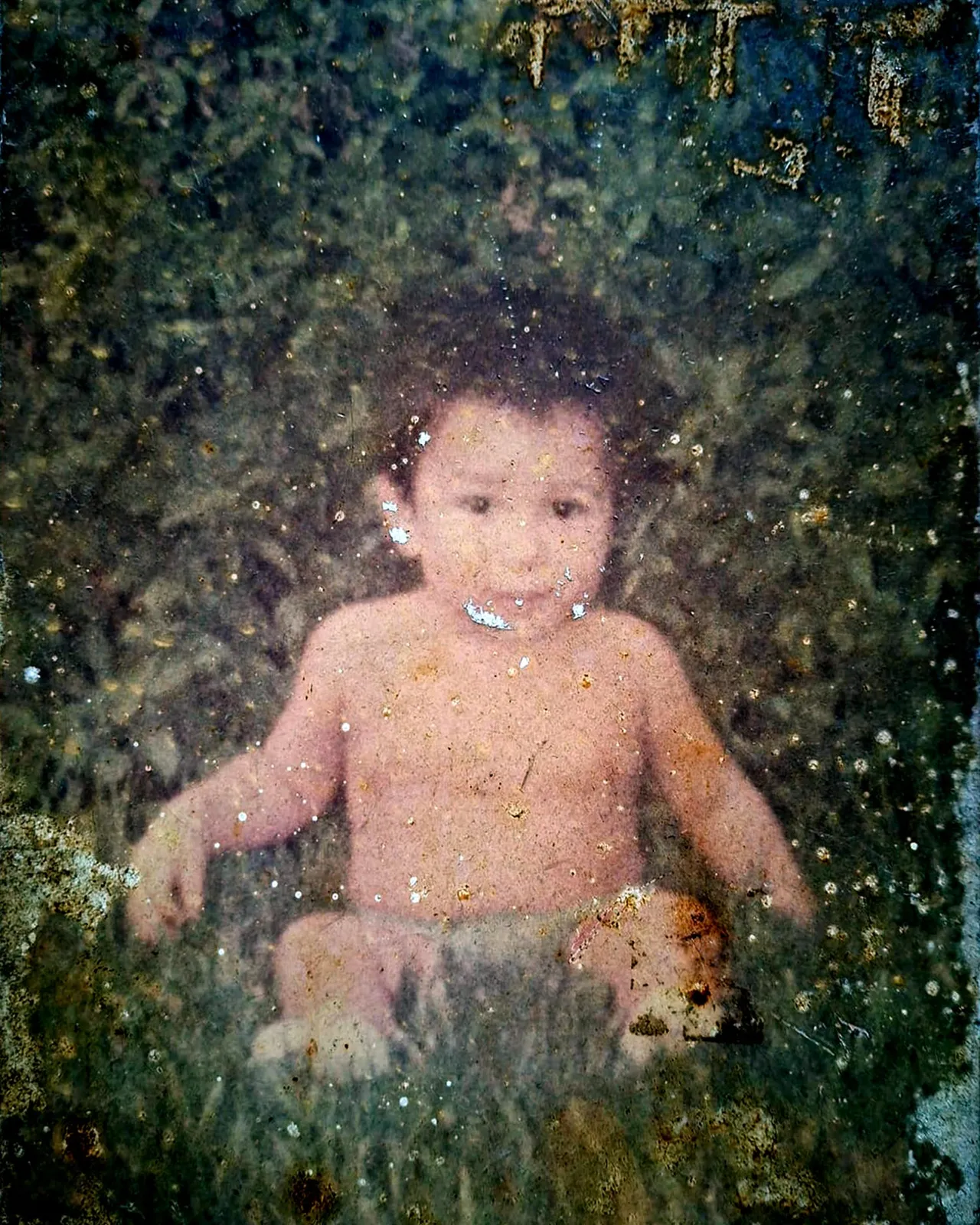 Foto de bebé cubierta por hongos y humedad, restaurada digitalmente por PixelPages - Antes
